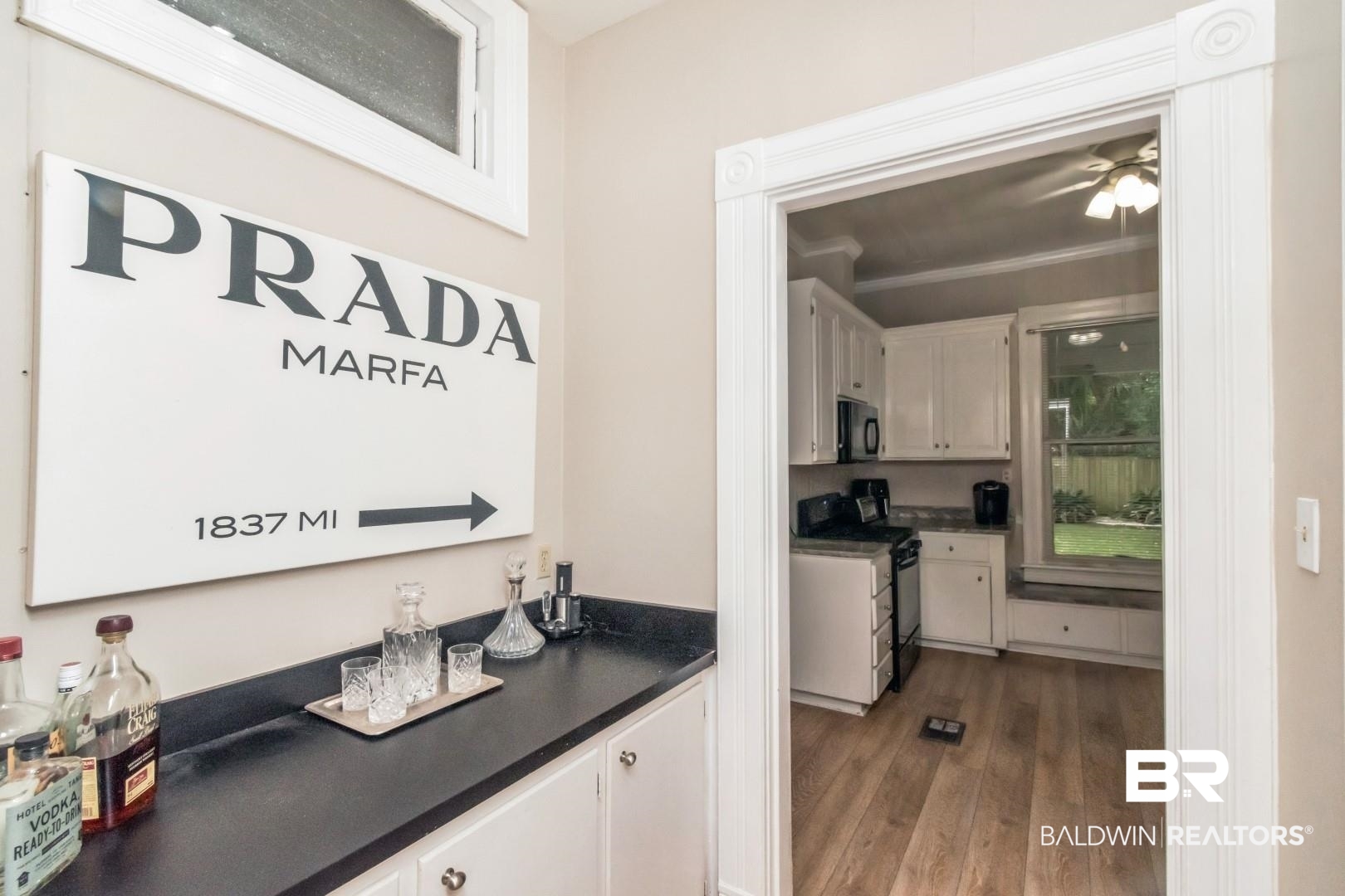 1305 Brown Street Mobile, AL 36604 - Photo 19 of 37 Bar with light hardwood / wood-style floors, black appliances, ornamental molding, and white cabinets