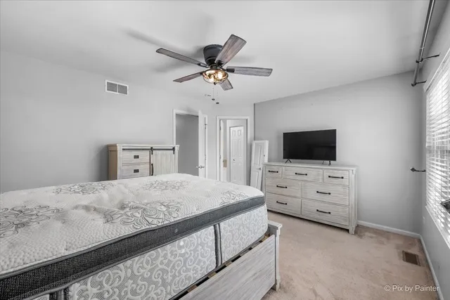 a bedroom with a bed flat screen tv and a window