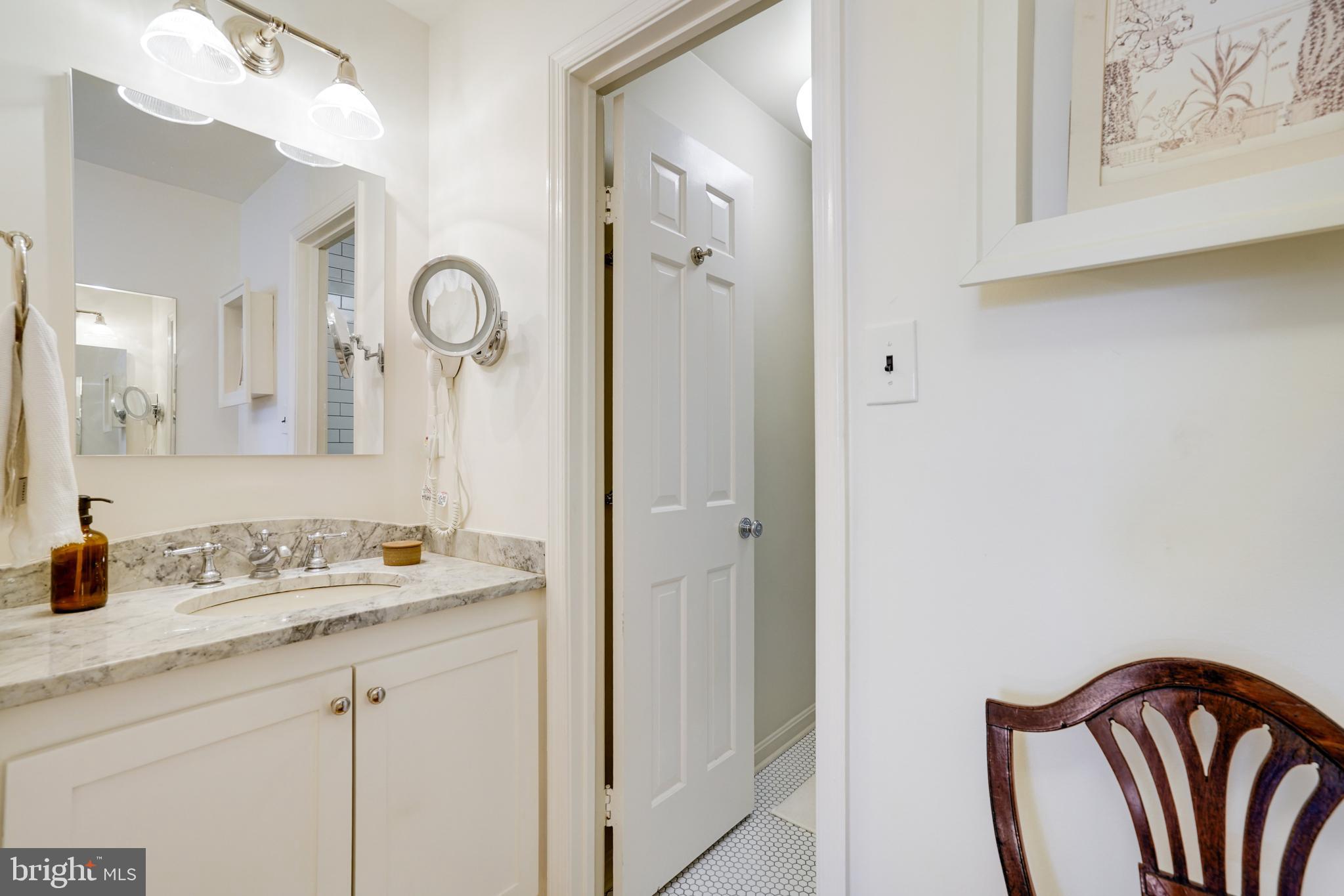817 Duke Street Alexandria, VA 22314 - Photo 27 of 39 a bathroom with a sink a mirror and a shower