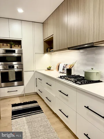 a kitchen with stainless steel appliances a stove a microwave and wooden cabinets
