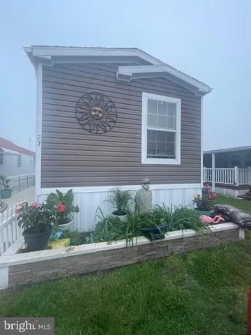 a front view of a house with a yard and potted plants