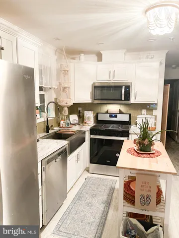a kitchen with a stove a sink and a refrigerator