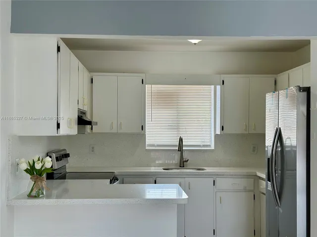 a kitchen with stainless steel appliances white cabinets and a sink