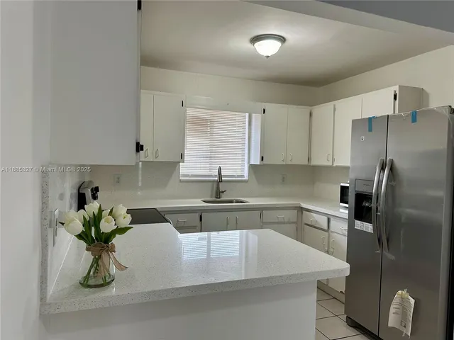 a kitchen with stainless steel appliances granite countertop a sink a stove and a refrigerator