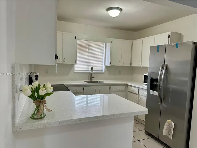 a kitchen with stainless steel appliances granite countertop a sink a refrigerator and a stove