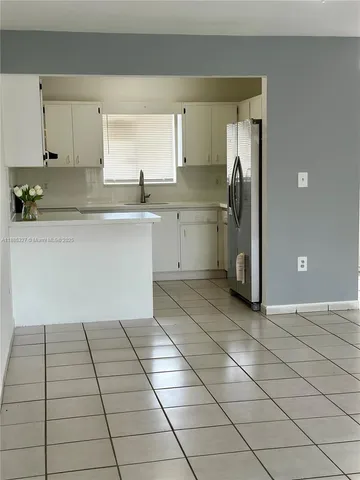 a kitchen with a sink a refrigerator and cabinets