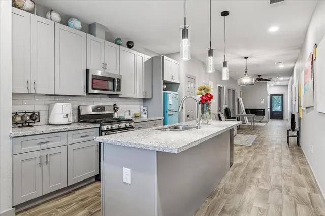 a kitchen with stainless steel appliances granite countertop a sink a stove and cabinets