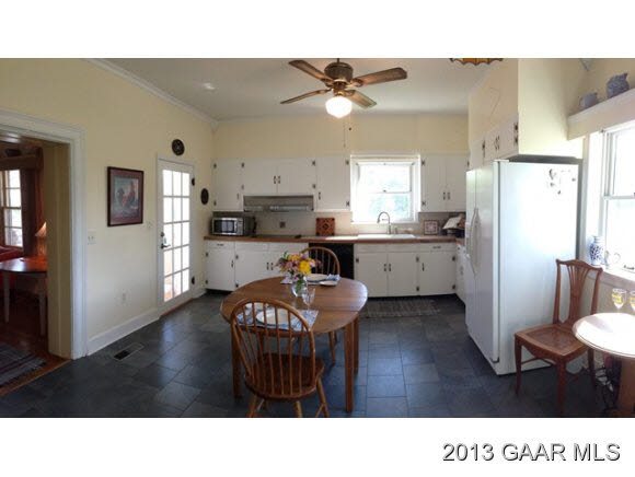 1766 Moffett Branch Road Churchville, VA 24421 - Photo 20 of 32 a kitchen with stainless steel appliances kitchen island granite countertop a refrigerator a stove a sink dishwasher and white cabinets with wooden floor next to windows