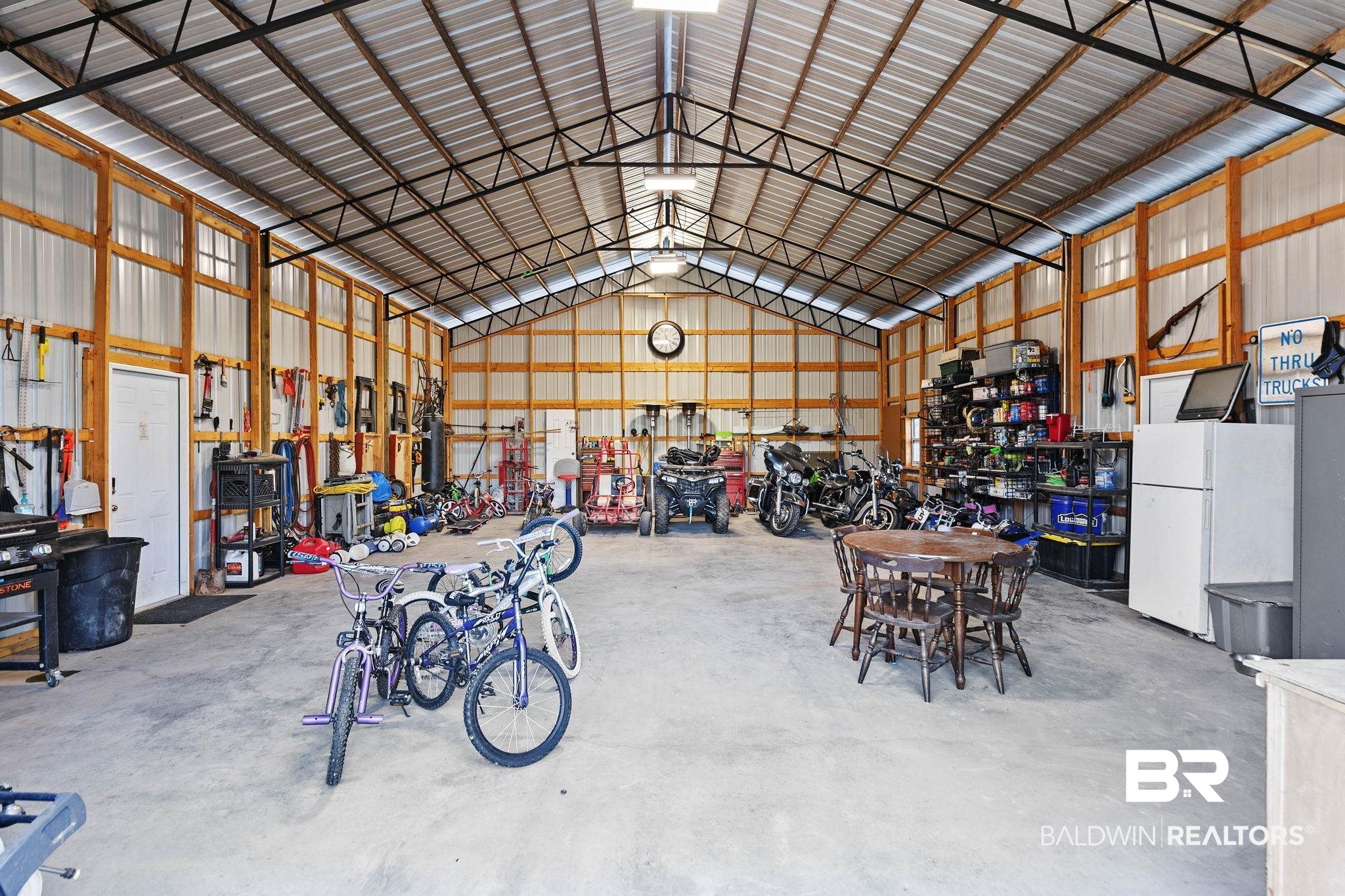 55750 Lottie Road Perdido, AL 36562 - Photo 37 of 84 Garage with freestanding refrigerator, metal wall, and a workshop area