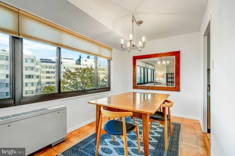 a dining room with wooden floor a chandelier a wooden table and chairs