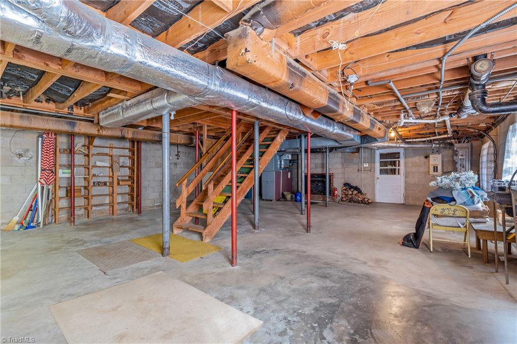 6356 Skylark Road Pfafftown, NC 27040 - Photo 37 of 48 Basement with woodstove and secondary laundry area