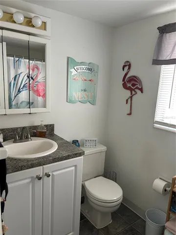 a bathroom with a granite countertop toilet sink and mirror