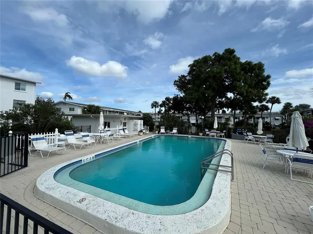 a view of a house with swimming pool and sitting area