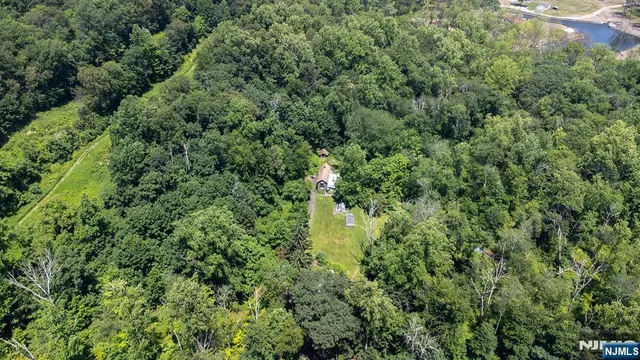 an aerial view of residential house with outdoor space and trees all around