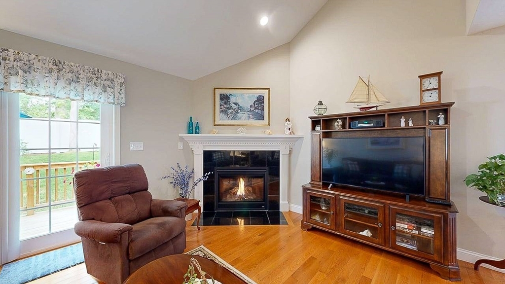 67 Cobblestone Lane, Unit 63 Worcester, MA 01606 - Photo 17 of 38 a living room with furniture a flat screen tv and a fireplace