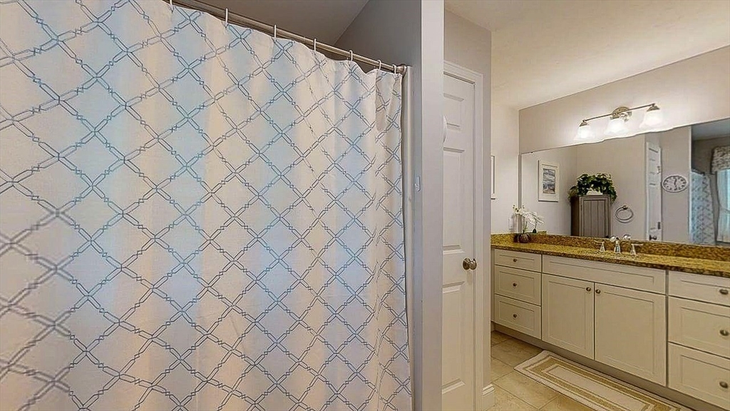67 Cobblestone Lane, Unit 63 Worcester, MA 01606 - Photo 20 of 38 a spacious bathroom with a granite countertop sink and a mirror on dresser
