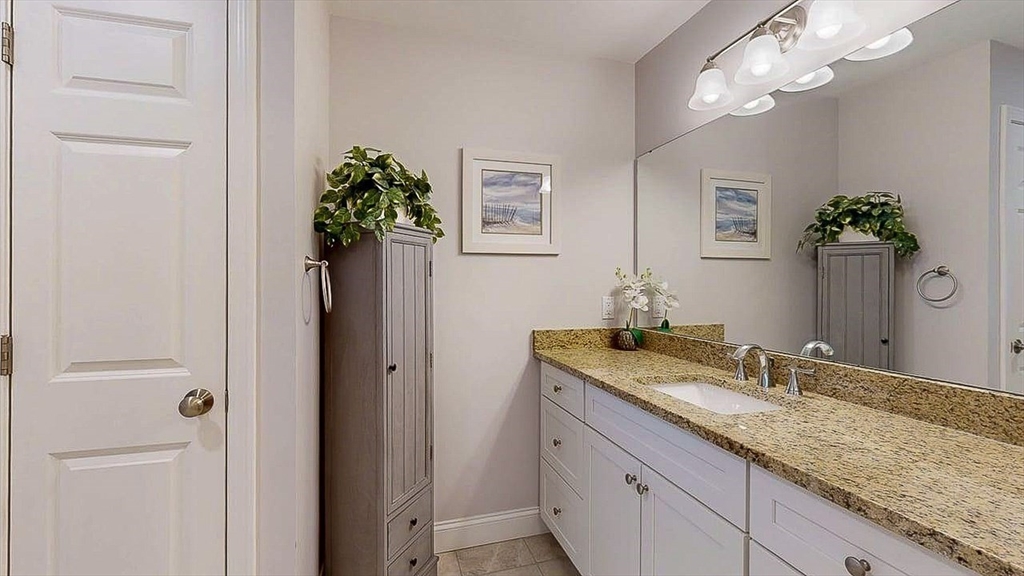 67 Cobblestone Lane, Unit 63 Worcester, MA 01606 - Photo 23 of 38 a bathroom with a granite countertop sink a potted plant and a mirror