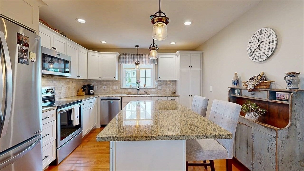 67 Cobblestone Lane, Unit 63 Worcester, MA 01606 - Photo 9 of 38 a kitchen with kitchen island granite countertop a sink a counter space appliances and cabinets