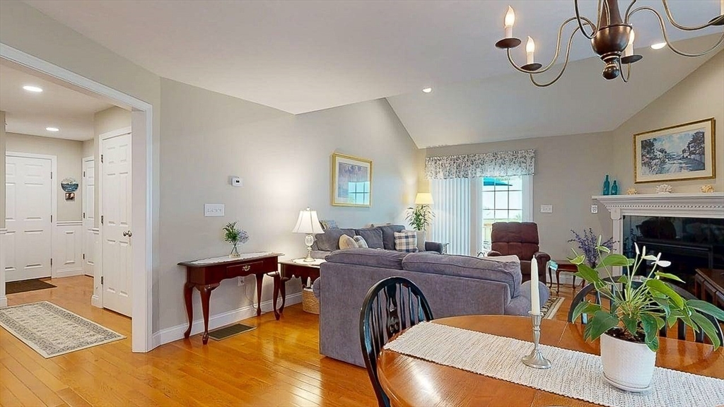 67 Cobblestone Lane, Unit 63 Worcester, MA 01606 - Photo 10 of 38 a living room with furniture a chandelier and a window