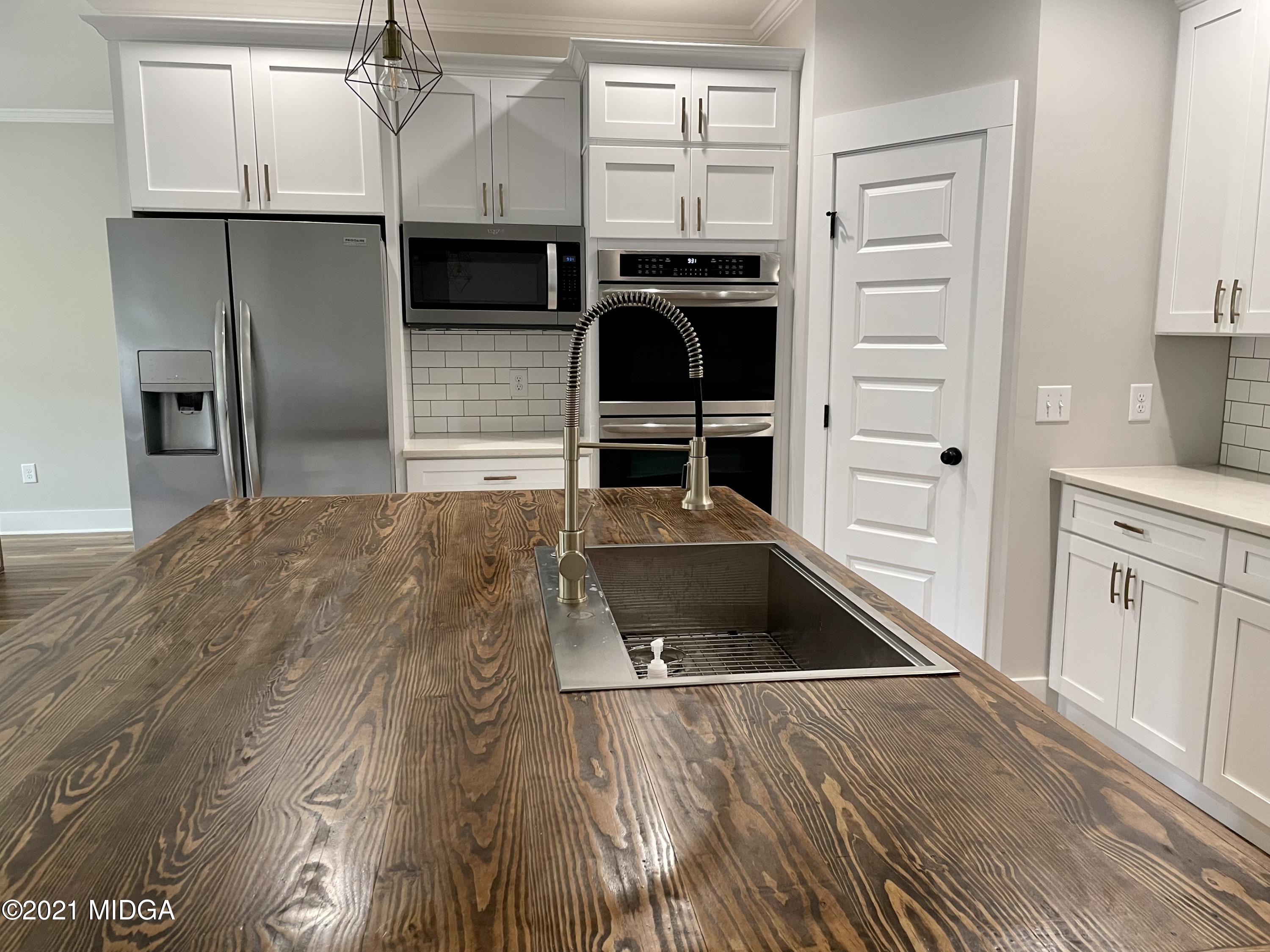 1194 Josey Road Forsyth, GA 31029 - Photo 4 of 9 a kitchen with granite countertop a refrigerator and a sink