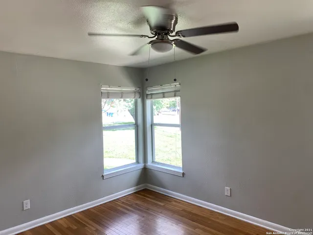 a view of room with hardwood floor and a ceiling fan