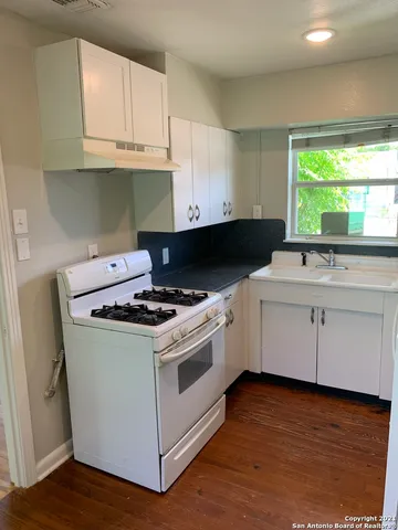 a white stove top oven sitting inside of a kitchen