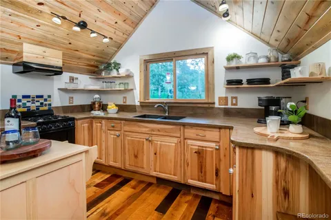 a kitchen with stainless steel appliances granite countertop a sink a stove cabinets counter space and a window