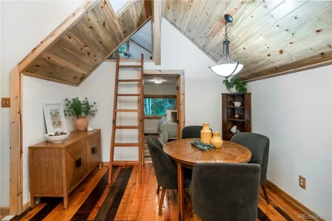 a dining room with wooden floor and furniture