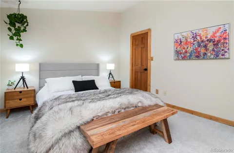 a bed sitting in a bedroom and painting on the wall