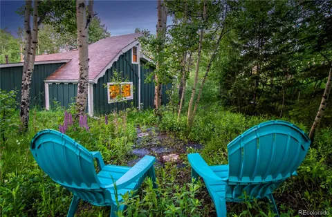 a view of a chair and fire pit in front of the house