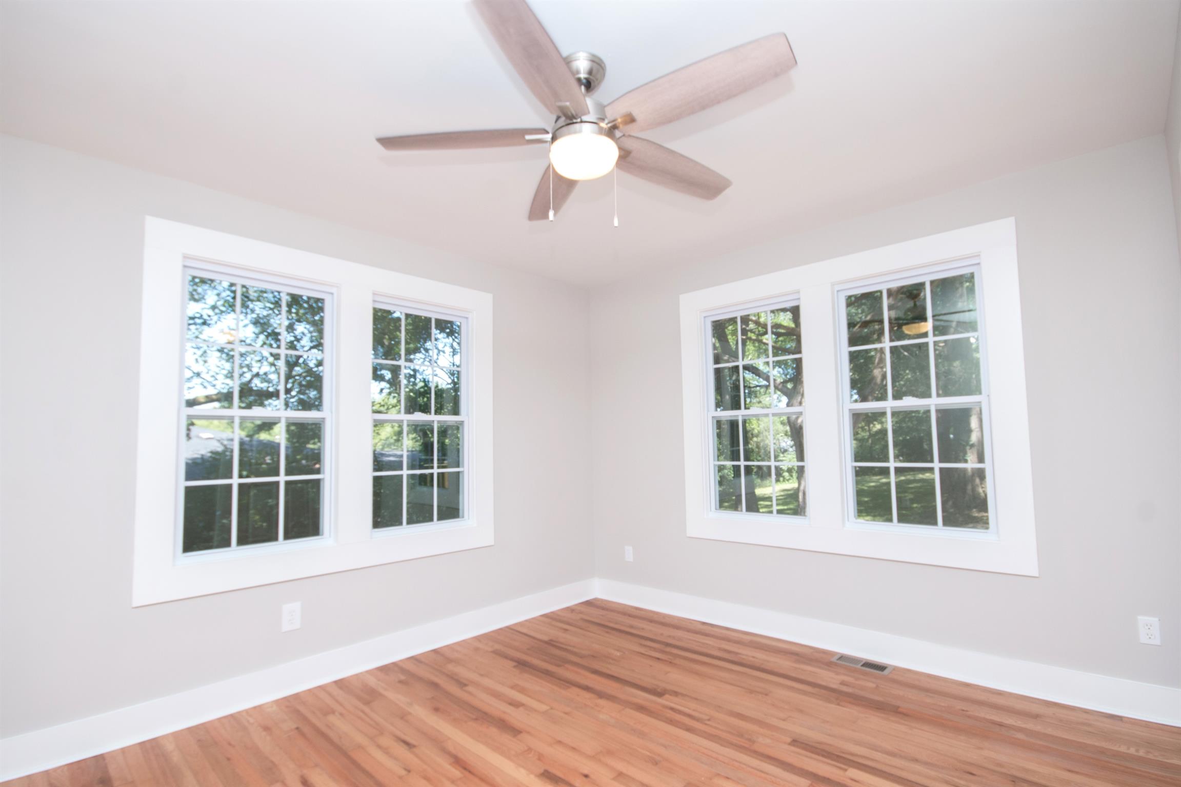 1003 Neelys Bend Road Madison, TN 37115 - Photo 11 of 30 an empty room with wooden floor and windows
