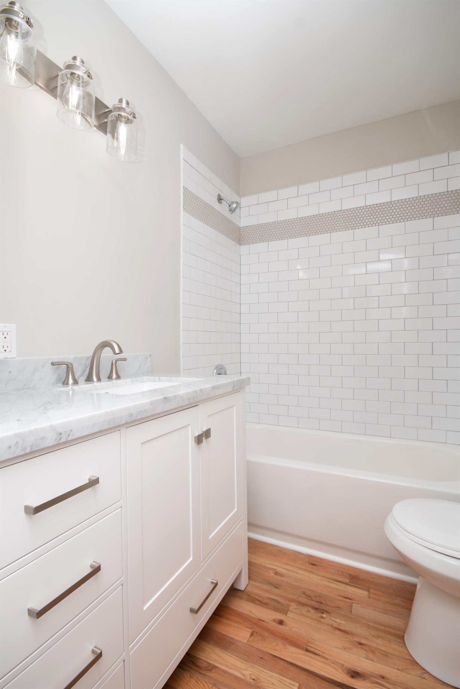 1003 Neelys Bend Road Madison, TN 37115 - Photo 12 of 30 a bathroom with a granite countertop sink a toilet and shower