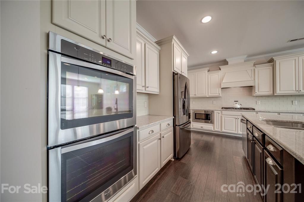 360 Monteray Oaks Circle Fort Mill, SC 29715 - Photo 12 of 44 a kitchen with stainless steel appliances white cabinets and a stove top oven