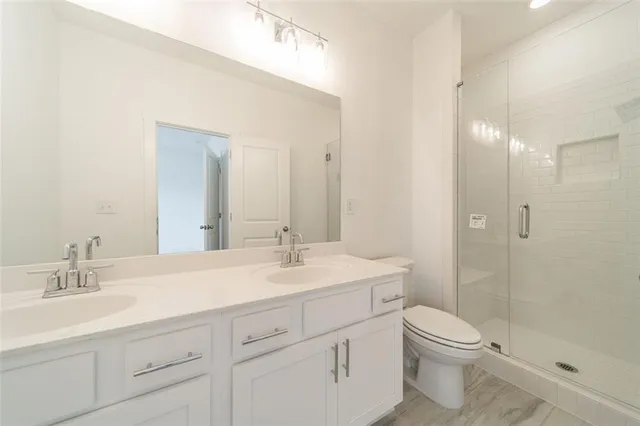 a bathroom with a sink a toilet a shower and a mirror