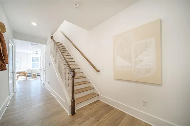 a view of a hallway with wooden floor and stairs