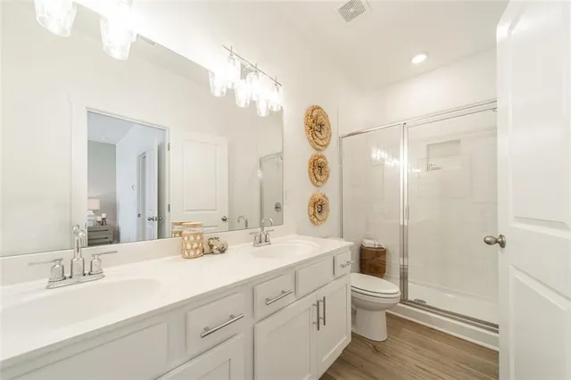 a bathroom with a double vanity sink mirror and toilet