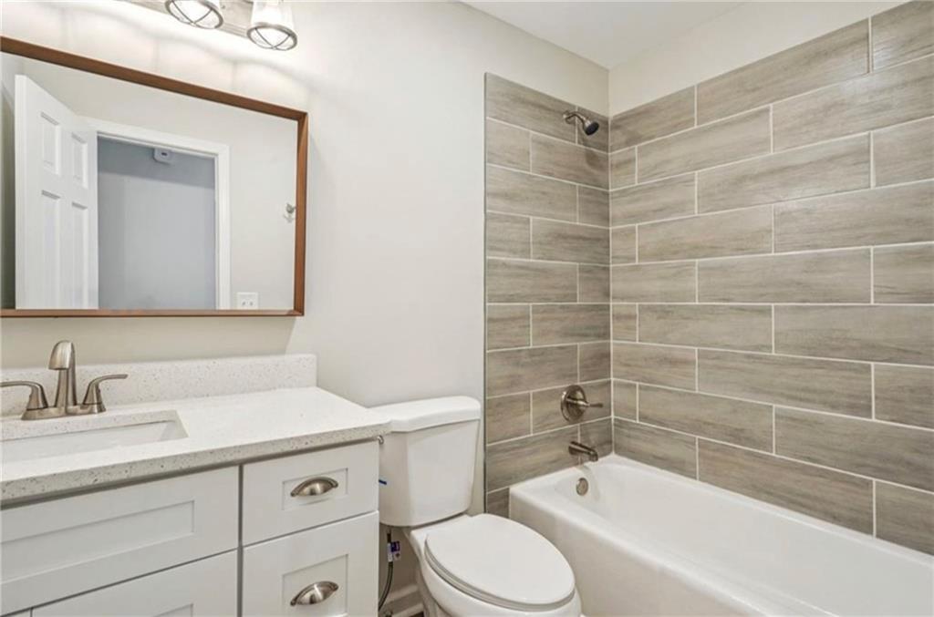141 Patterson Road Southwest Lawrenceville, GA 30044 - Photo 24 of 34 a bathroom with a bathtub shower sink mirror vanity and toilet