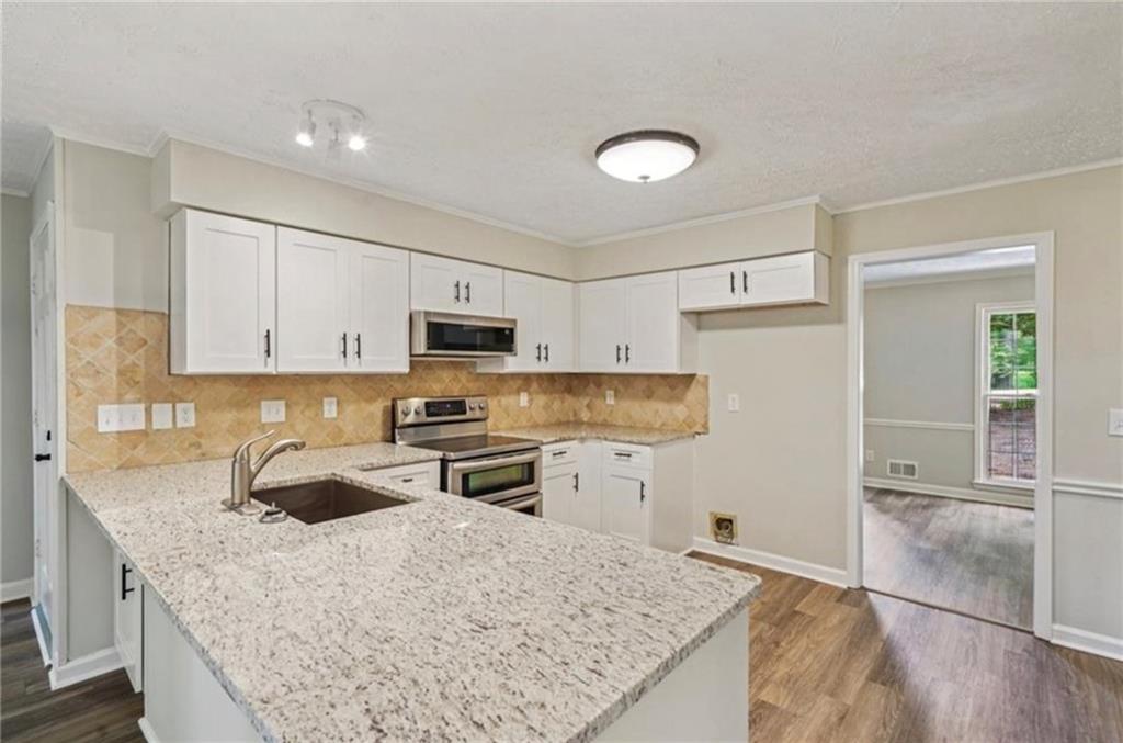 141 Patterson Road Southwest Lawrenceville, GA 30044 - Photo 5 of 34 a kitchen with stainless steel appliances granite countertop a sink stove and refrigerator