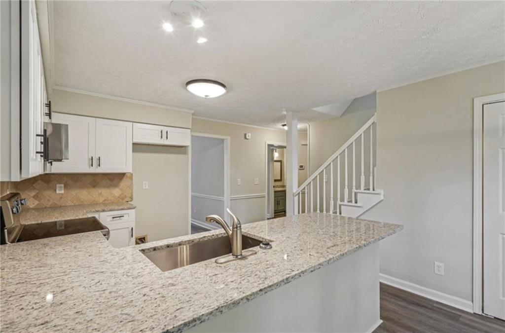 141 Patterson Road Southwest Lawrenceville, GA 30044 - Photo 6 of 34 a kitchen with granite countertop a sink a stove and a refrigerator