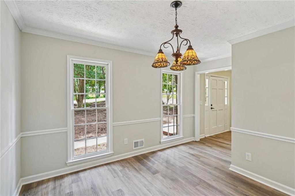 141 Patterson Road Southwest Lawrenceville, GA 30044 - Photo 10 of 34 a room with wooden floor chandelier and windows
