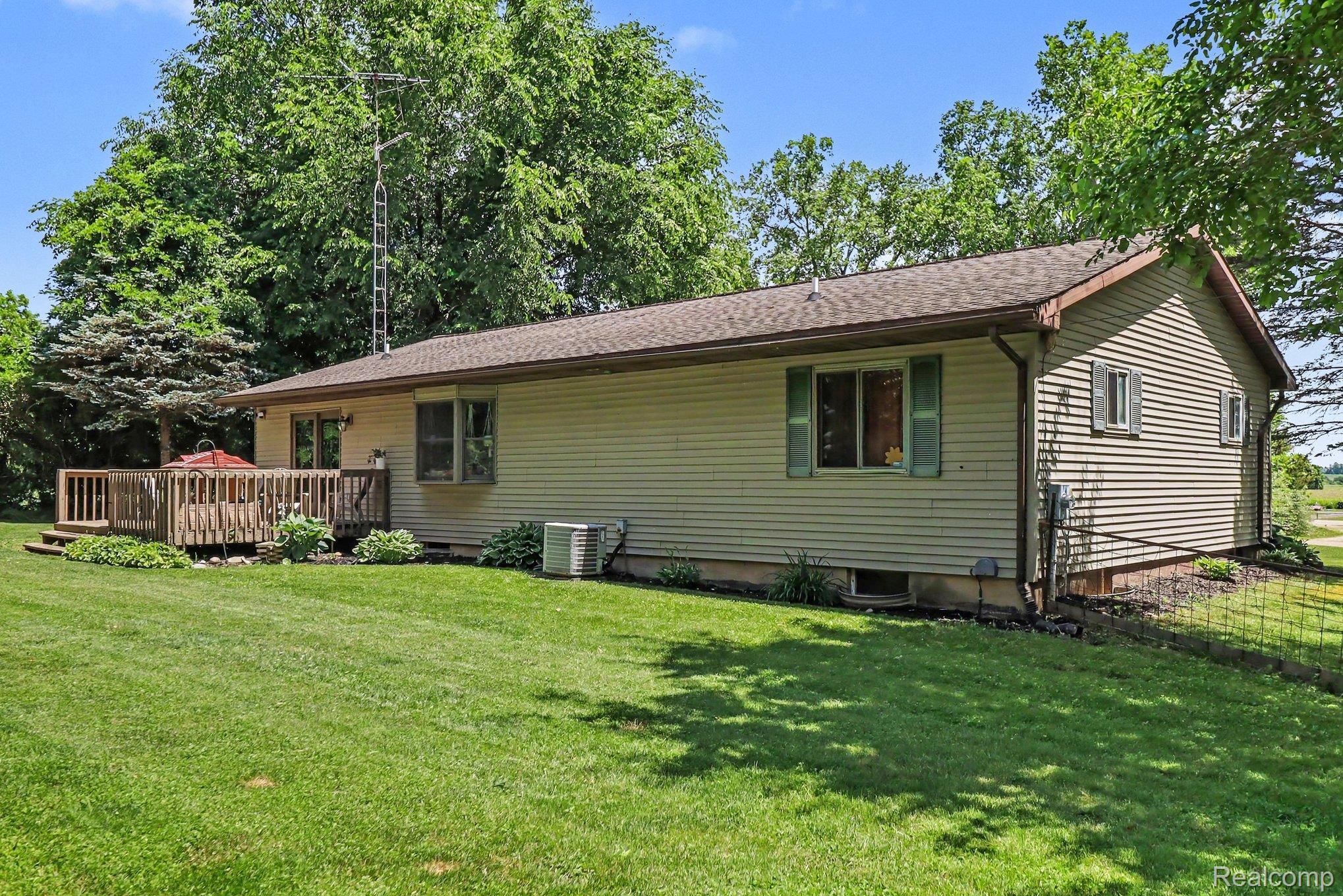 2905 German Road Columbiaville, MI 48421 - Photo 27 of 31 Expansive green lawn bordering a wood deck with railings