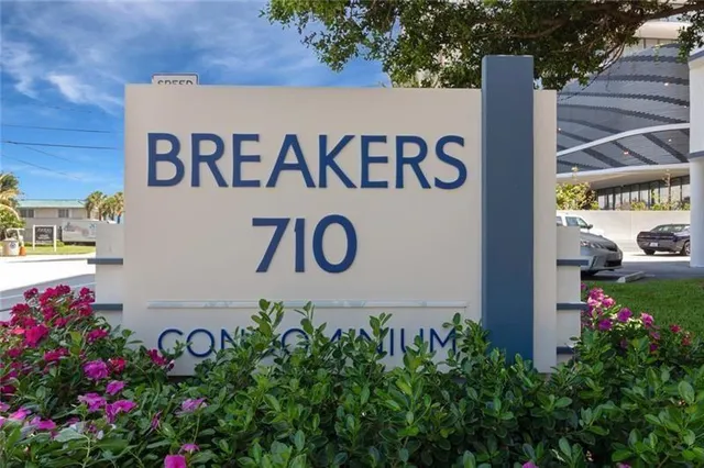 a sign that is sitting in front of flowers