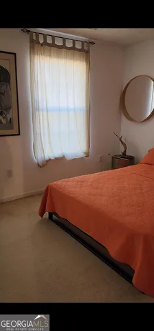 a bedroom with a bed and a painting on the wall