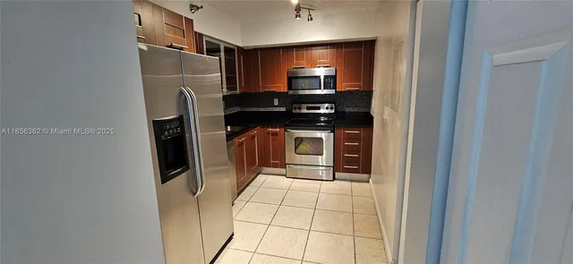 a kitchen with stainless steel appliances a refrigerator and a counter top space