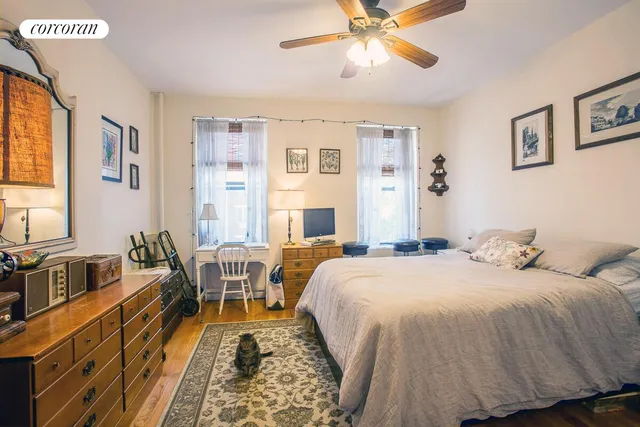 a bedroom with a bed and a dresser next to a window