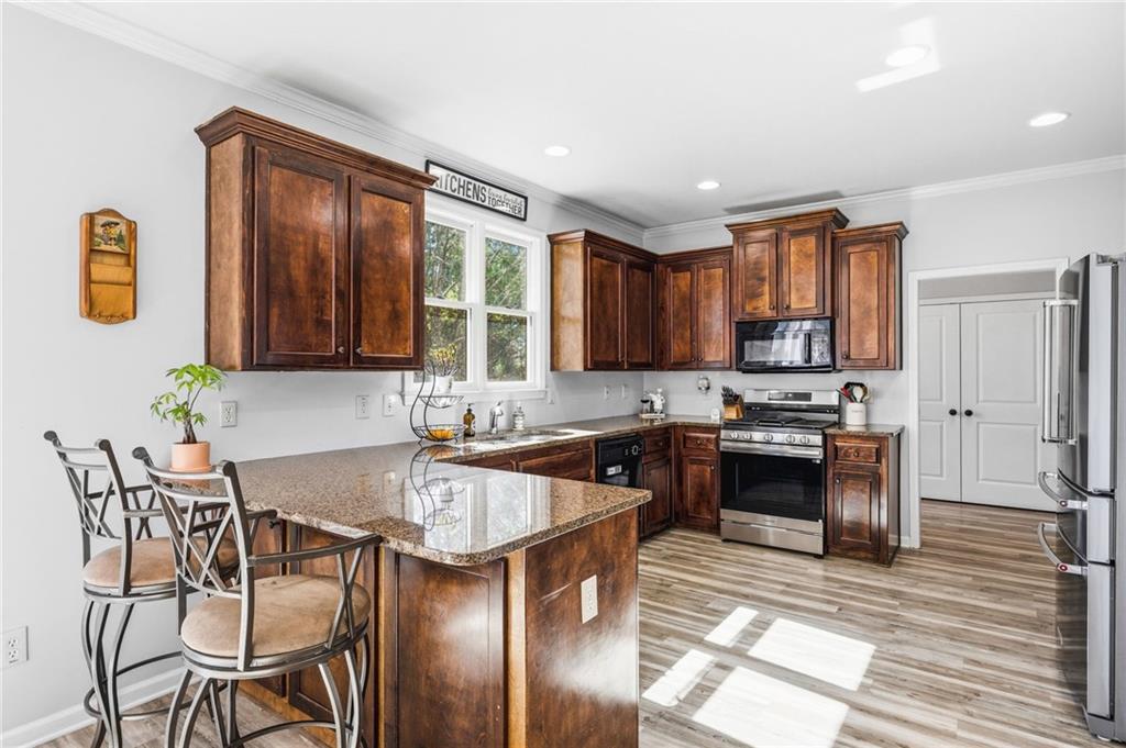 313 Spring Hill Drive Canton, GA 30115 - Photo 12 of 35 a kitchen with granite countertop a stove top oven a sink dishwasher a dining table and chairs with wooden floor