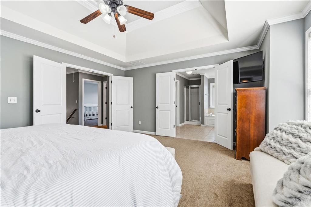 313 Spring Hill Drive Canton, GA 30115 - Photo 19 of 35 a spacious bedroom with a bed and a chandelier