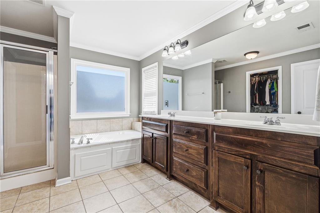 313 Spring Hill Drive Canton, GA 30115 - Photo 21 of 35 a spacious bathroom with a double vanity sink a mirror a bathtub and a window