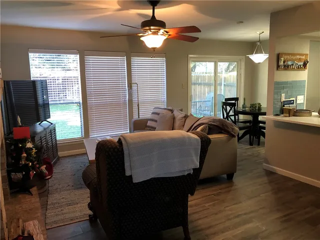 a living room with furniture flat screen tv and windows