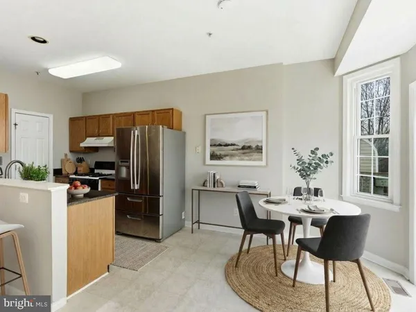 a kitchen with a refrigerator sink and wooden cabinets
